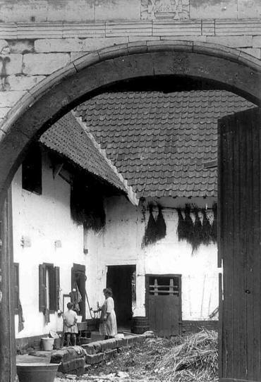 Poort met jaartal 1683. Aan de pomp: Catharina Duijsens-Frijns (ca. 1923)